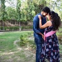 Indian couple posing for maternity baby shoot. The couple is posing in a lawn with green grass and the woman is falunting her baby bump in Lodhi Garden in New Delhi, India photo