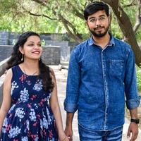 Indian couple posing for maternity baby shoot. The couple is posing in a lawn with green grass and the woman is falunting her baby bump in Lodhi Garden in New Delhi, India photo