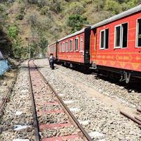 Toy Train moving on mountain slopes, beautiful view, one side mountain, one side valley moving on railway to the hill, among green natural forest. Toy train from Kalka to Shimla in India, Indian Train photo