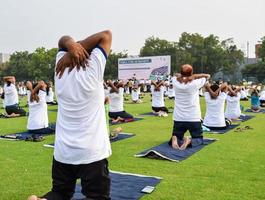 Group Yoga exercise session for people of different age groups at cricket stadium in Delhi on International Yoga Day, Big group of adults attending yoga session photo