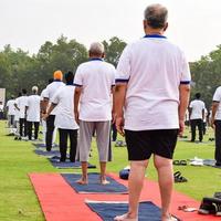 Group Yoga exercise session for people of different age groups at cricket stadium in Delhi on International Yoga Day, Big group of adults attending yoga session photo