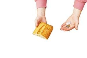 último dinero para el pan. pan en la mano de una mujer de mediana edad. el concepto de la crisis alimentaria mundial asociada con la guerra en ucrania. aislado sobre fondo blanco foto