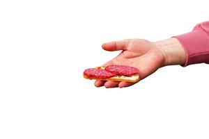 Sandwich with sausage in the hand of a middle-aged woman. The concept of the world food crisis associated with the war in Ukraine. Isolated on white background photo