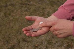 último dinero para la compra. monedas en la mano de una mujer de mediana edad. el concepto de la crisis alimentaria mundial asociada con la guerra en ucrania foto