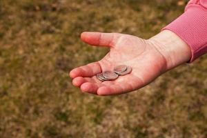 último dinero para la compra. monedas en la mano de una mujer de mediana edad. el concepto de la crisis alimentaria mundial asociada con la guerra en ucrania foto