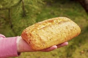 pan en la mano de una mujer de mediana edad. el concepto de la crisis alimentaria mundial asociada con la guerra en ucrania foto