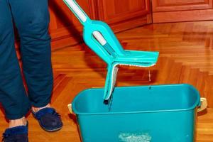 Mop your wood floor. A woman prepares a mop. Housekeeping concept. photo