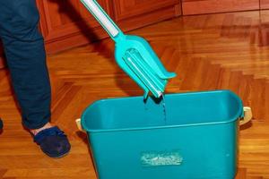 Mop your wood floor. A woman prepares a mop. Housekeeping concept. photo