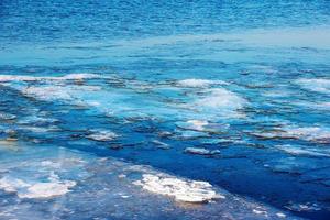 Ice surface of the river. The texture of fragments of ice and water during the icing period. Winter background. photo