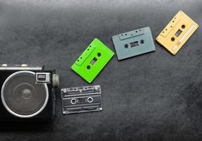 Top view half retro radio and colorful cassette tape on black floor with copy space photo