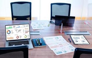 Mock up sales summary slide show presentation on display  laptop and paperwork on table with clear acrylic sheet separates the center on the conference table to prevent Covid-19 in meeting room photo