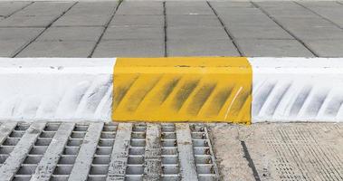 Yellow and white color curb stained with tires. photo