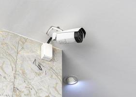 CCTV security camera on white ceiling photo