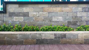 un muro de piedra natural, algunas plantas y una sala de estar con un camino de madera, un hermoso parque moderno al aire libre de diseño simple del arquitecto. foto