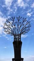 Super tree grove, a place to grow vines plant, the iron decoration looks like a towering tree with a blue sky background. photo