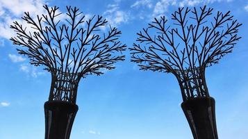 Super tree grove, a place to grow vines plant, the iron decoration looks like a towering tree with a blue sky background. photo