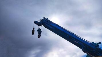 Blue telescopic crane soaring into the sky with blue sky background. photo