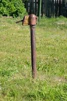 old rusty water column on the street, in the village photo