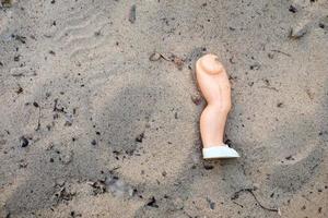 broken doll leg in the sand photo