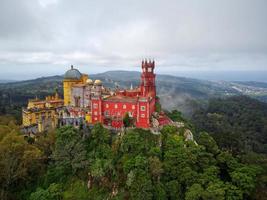 Aerial drone view of Park and National Palace of Pena in Sintra, Portugal during a magical day. Unesco. Historic visits. Sightseeing. Fairytale. Best destinations in the world. Most visited places. photo