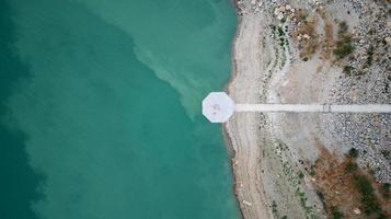 Aerial drone view of low levels of the dam river. Shortage of water.  Climate change. Severe drought. Global warming. Environmental disaster. No water to dry agriculture fields. photo