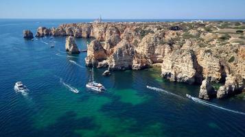 vista aérea de drones de barcos y kayaks en el océano atlántico, lagos, algarve, portugal. exploración de cuevas y túneles. viajes y aventuras. vacaciones y vacaciones. hermoso color azul del océano. foto