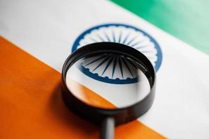 Indian flag looking through a magnifying glass. Total surveillance of the country Indian. The concept of hidden threats and control over the country photo