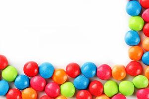 A rainbow of color from multicolored candies close-up, multi-colored glaze dragee on a white background photo