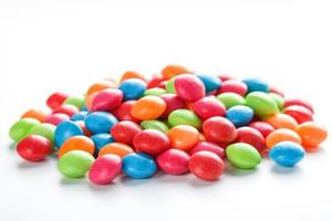 Rainbow-colored candies, multicolored close-up, texture and repetition of dragee photo