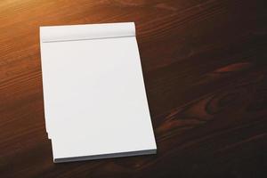 Notebook with a red pencil on a brown background with warm sunlight, for writing. Free empty space for writing on a blank sheet of a notebook. photo