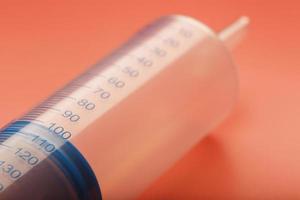 Large medical syringe on pink background with scale, copy space. photo