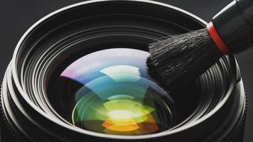 Brush cleaning the camera Lens with a beautiful close-up optical unit. photo