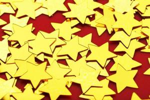 una dispersión de estrellas doradas sobre fondo rojo. el concepto de tarjetas de felicitación, titulares y sitio web. foto