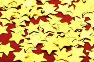 A scattering of Gold stars on a red background. Greeting cards, headlines and website concept. photo