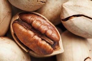 Pecan nuts close-up, macro as the background on the whole screen. Peeled, in a shell. photo