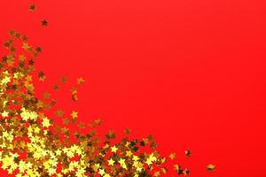 Gold stars on red background. The concept of greeting cards, headlines and web site. A scattering of Golden stars photo