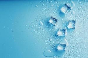 cubos de hielo con gotas de agua derretida sobre un fondo azul, vista superior.