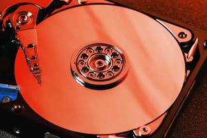 The hard disk from the computer HDD is red, with a mirror effect. The hard drive from the computer has opened. photo