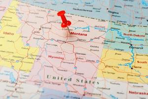 Red clerical needle on a map of USA, Montana and the capital of Helena. Close up Montana map with red tack photo