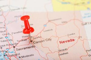 Red clerical needle on a map of USA, Nevada and the capital Carson City. Closeup Map Nevada with Red Tack photo