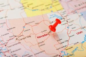 Red clerical needle on a map of USA, Nevada and the capital Carson City. Closeup Map Nevada with Red Tack photo