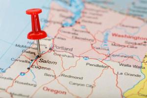 Red clerical needle on a map of USA, Oregon and the capital Salem. Closeup Map Oregon with Red Tack photo