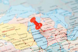 Red clerical needle on a map of USA, Michigan and the capital Lansing. Close up map of Michigan with red tack photo