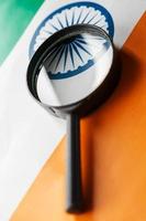 Indian flag looking through a magnifying glass. Total surveillance of the country Indian. The concept of hidden threats and control over the country photo