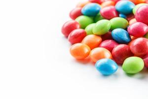 A rainbow of color from multicolored candies close-up, multi-colored glaze dragee on a white background photo