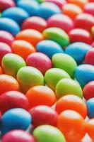 Rainbow colors of multicolored candies close-up, texture and repetition of dragee photo