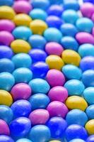 textura-fondo de caramelos multicolores. colores del primer plano del arco iris, textura y repetición de la gragea foto