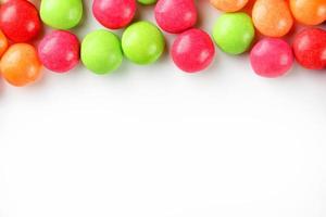 A rainbow of color from multicolored candies close-up, multi-colored glaze dragee on a white background photo