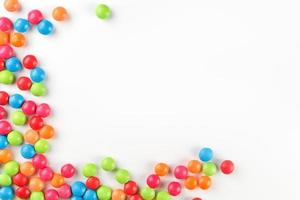 A rainbow of color from multicolored candies close-up, multi-colored glaze dragee on a white background photo