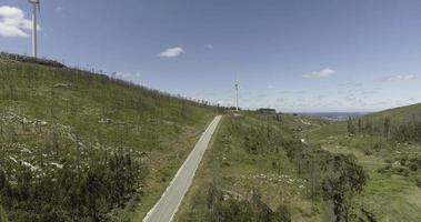 vento turbine rotante su il verde montagne nel reguengo fare fetale, Batalha, Portogallo su un' soleggiato giorno - angolo ampio, ascendente fuco tiro video
